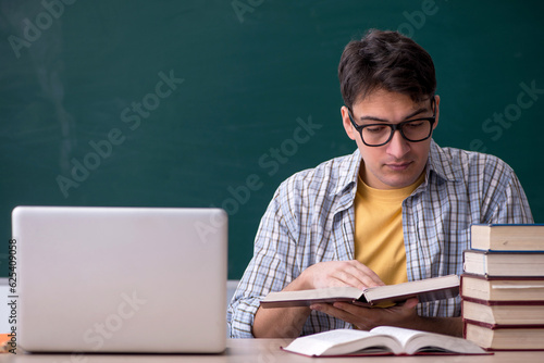 Young male student preparing for exams in the classroom
