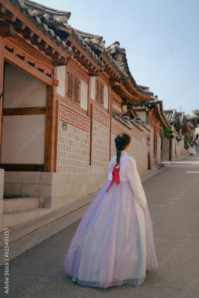 Obraz premium Tourist girl wearing a traditional korean hanbok at the Hanok Village in Seoul, South Korea.