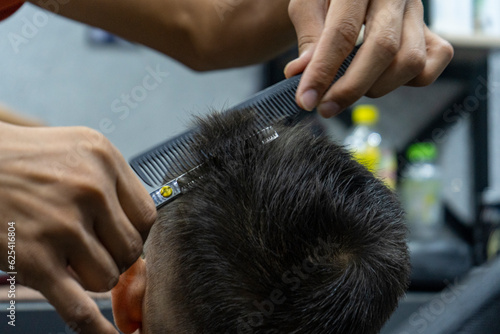 a barber man cutting with a hairdressing scissors