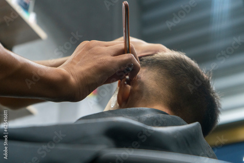 a barber using razor blade on a child