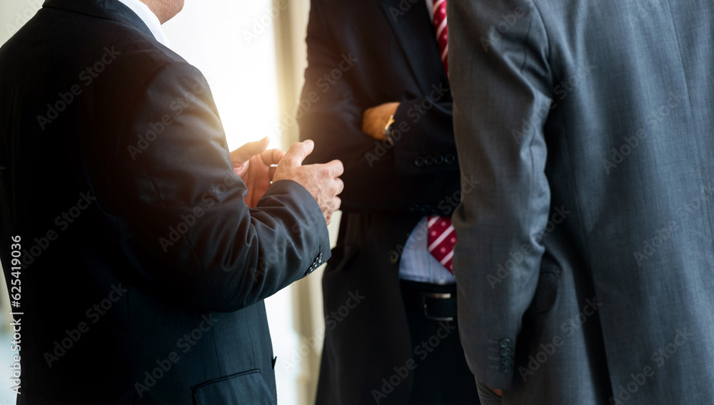 Three businessmen standing together communicating Three businessmen standing together communicating