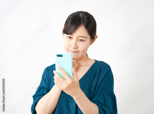 スマートフォンを見て考える女性 白背景