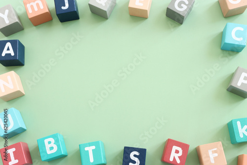 Платно Wooden cubes with English letters on a pastel green background