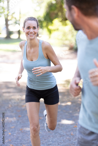 female runner jogging during outdoor workout in a park