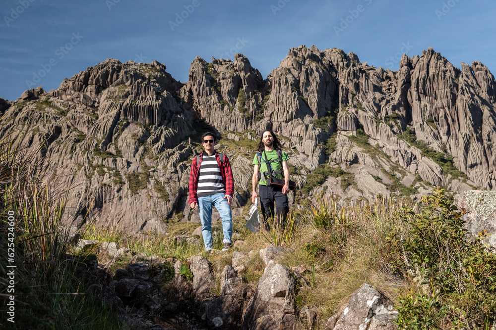 Beautiful view to couple of friends hiking on altitude fields