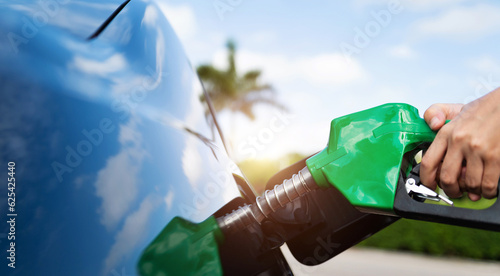 Hand refilling the car with fuel at the gas station