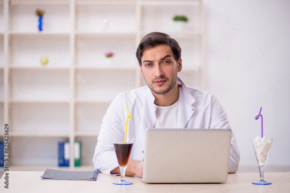 Young male chemist examining soft drink