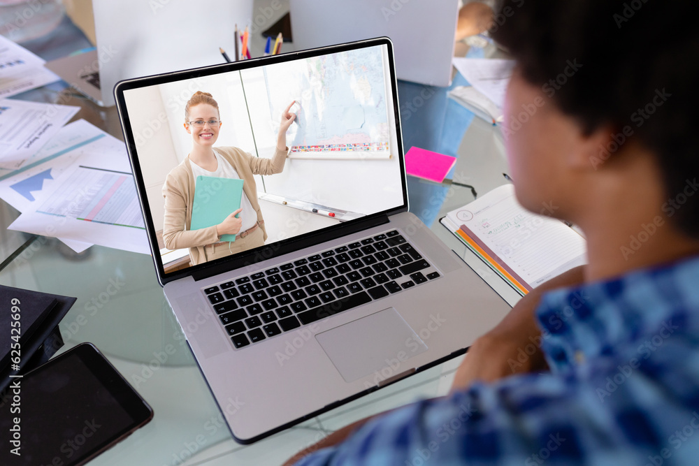 African american boy looking at female teacher teaching over video call on laptop screen African american boy looking at female teacher teaching over video call on laptop screen