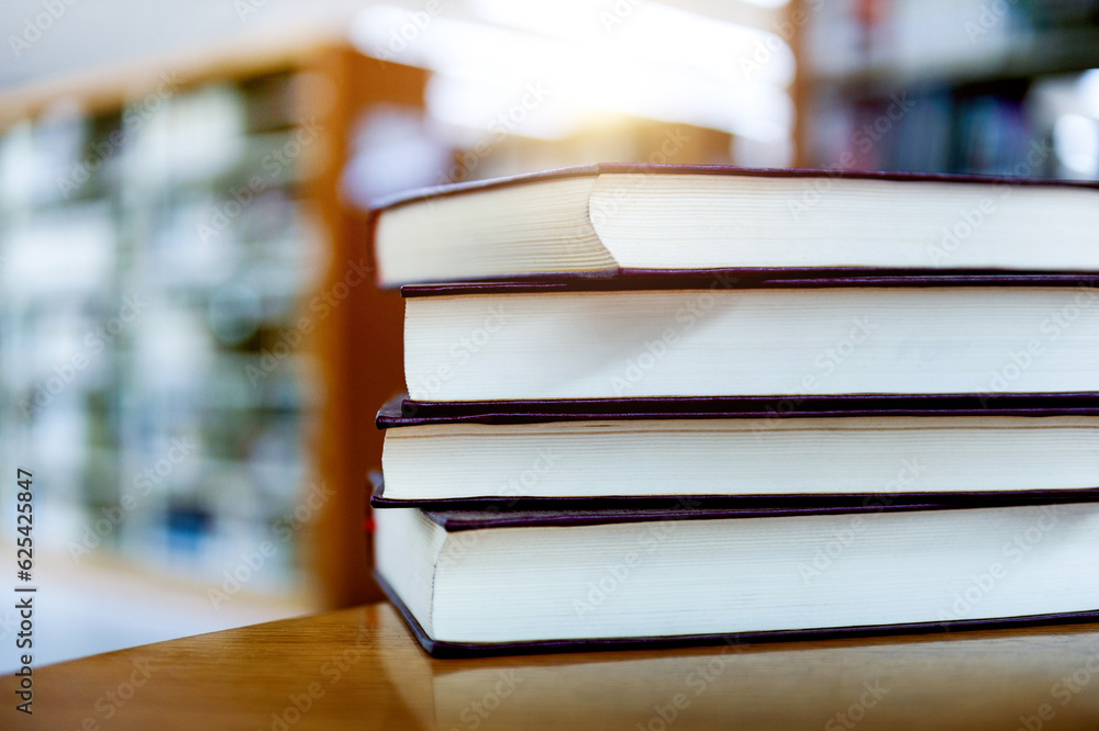 Library with four books stacked on desk Library with four books stacked on desk