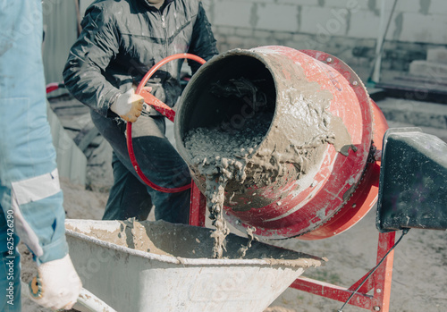 Canvastavla Worker pouring concrete with cement mixer at construction site, closeup