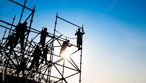 Group of construction workers working on scaffolding photo