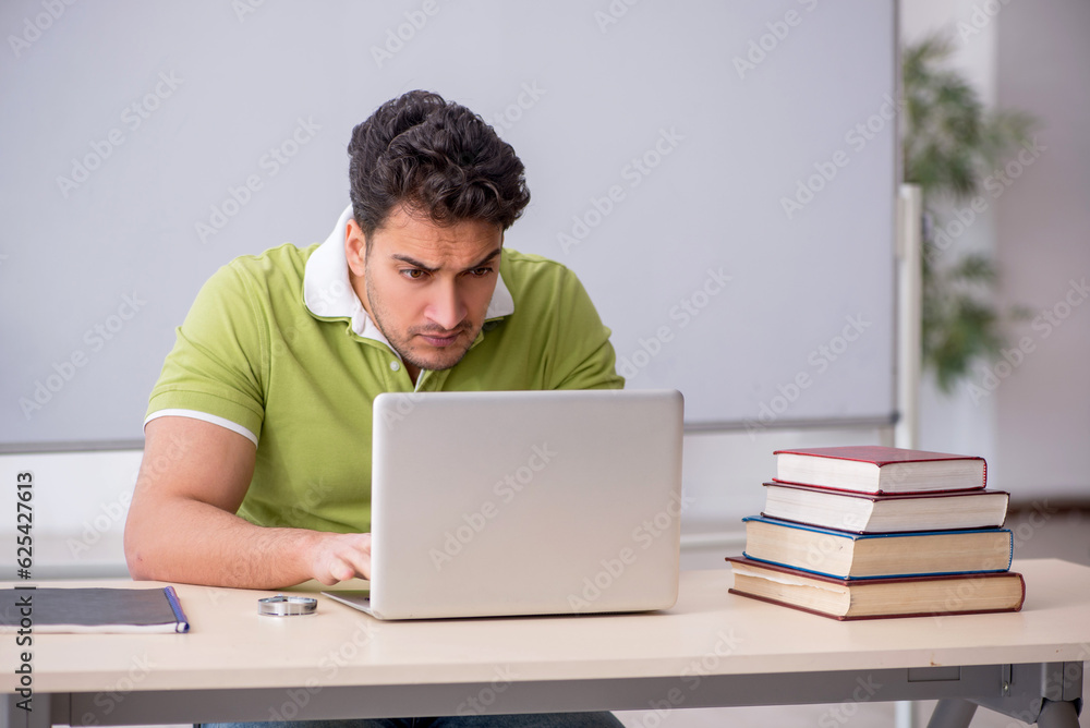 Young male student in telestudying concept Young male student in telestudying concept