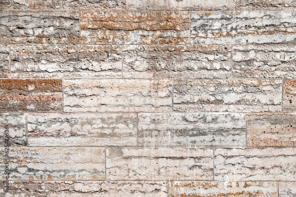 Fototapeta premium Texture of an old pink stone wall made of limestone blocks as an architectural background