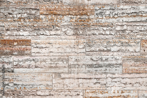 Texture of an old pink stone wall made of limestone blocks as an architectural background