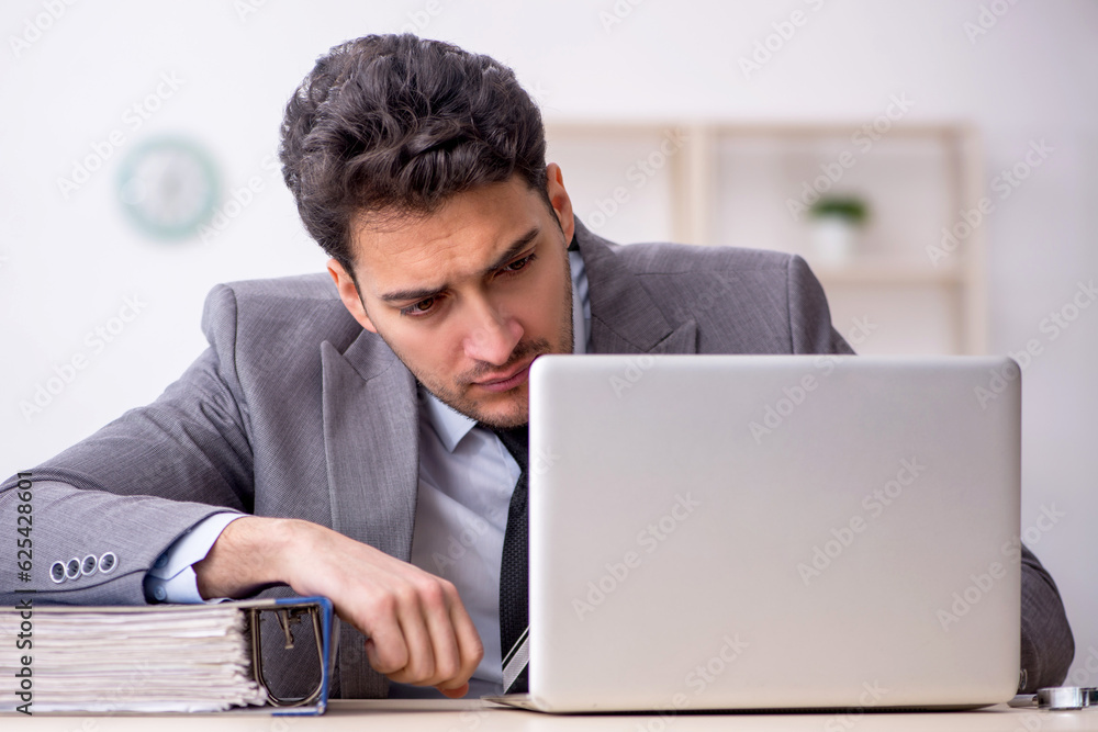 Young male employee working in the office Young male employee working in the office
