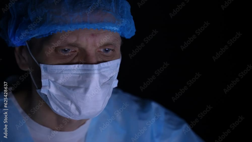 Medic in a mask in front of a PC monitor. Dolly shot. Close-up Medic in a mask in front of a PC monitor. Dolly shot. Close-up