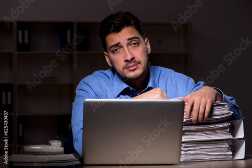 Young male employee working late in the office