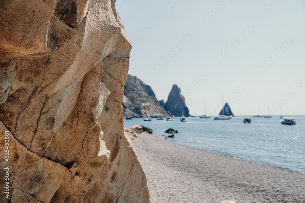 calm azure sea and volcanic rocky shores. Small waves on water surface in motion blur. Nature summer ocean sea beach background. Nobody. Holiday, vacation and travel concept