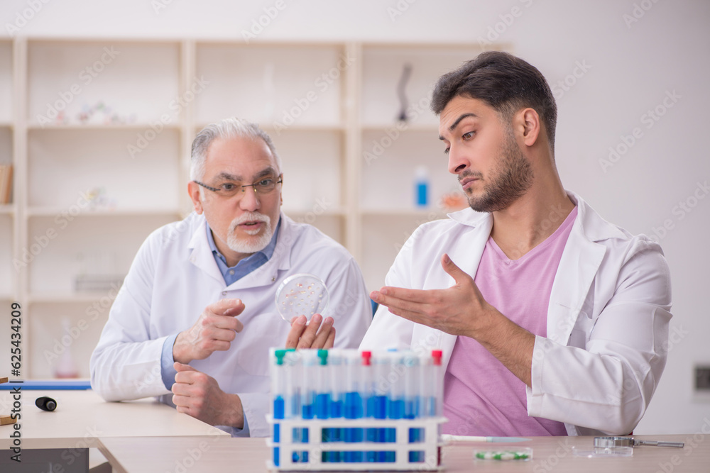 Two male chemists working at the lab Two male chemists working at the lab