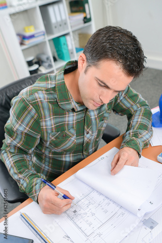 Fotografie Man at desk working on plans in file