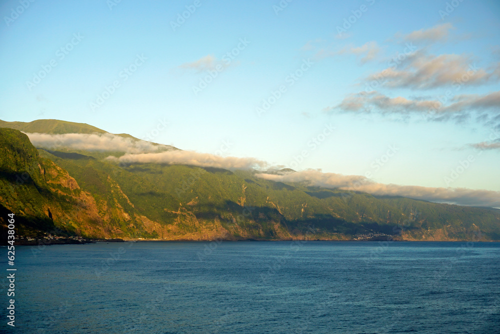 Panoramic view of rocks above the ocean on Madeira island. Atlantic. Clouds and shadows under the clouds.