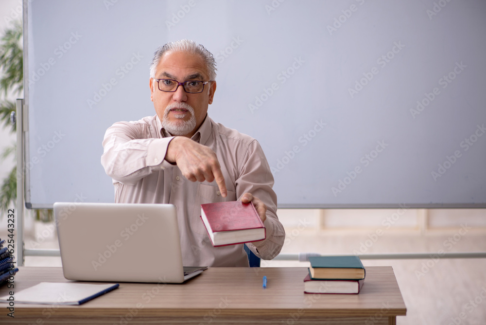 Old male teacher in front of whiteboard Old male teacher in front of whiteboard