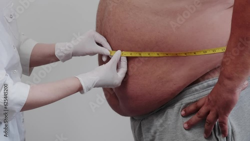 the doctor measures the fat man measures the beer belly.