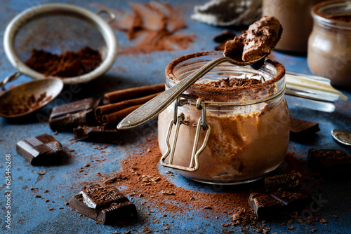 Delicious homemade Chocolate panna cotta or chocolate mousse in a glass jar decorated with cocoa powder and grated dark chocolate photo