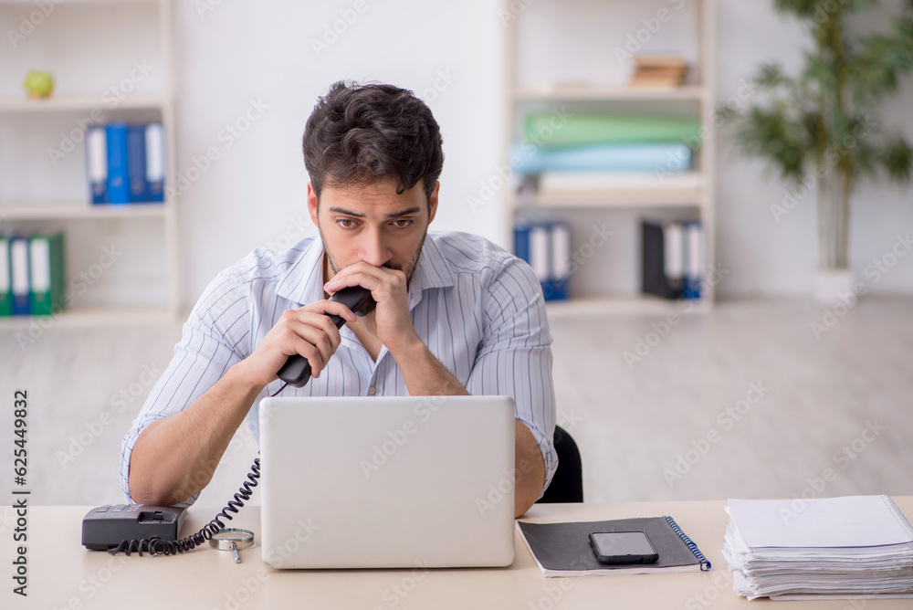 Young male employee working in the office Young male employee working in the office