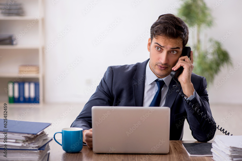Young male employee working in the office Young male employee working in the office