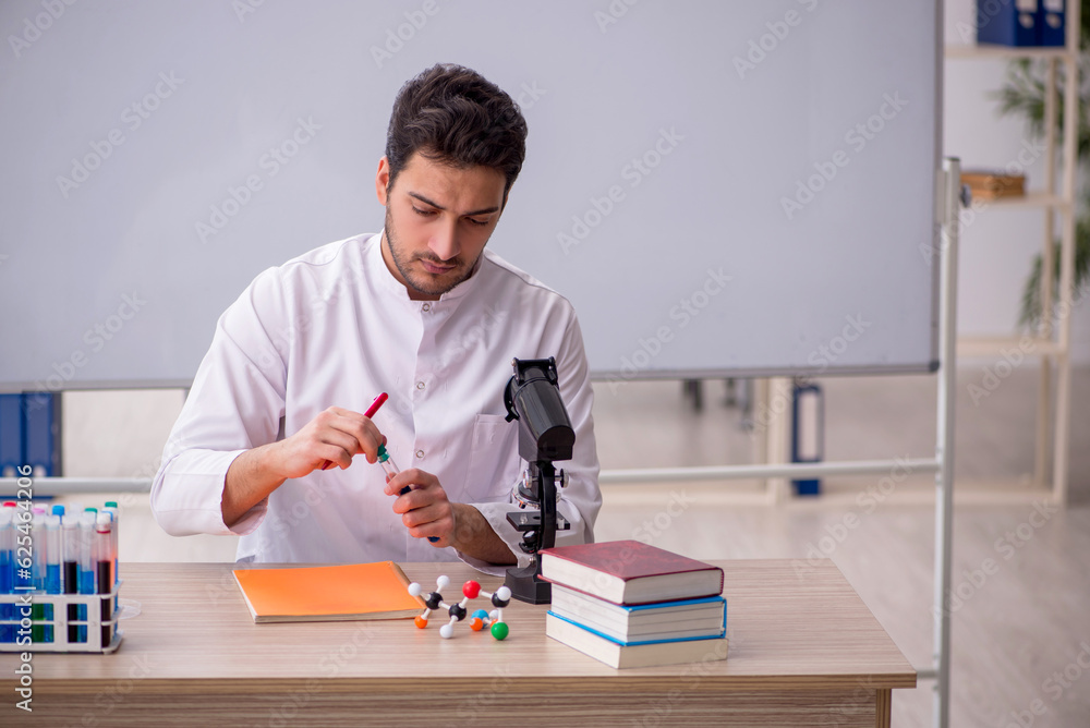 Young male chemist sitting in the classroom Young male chemist sitting in the classroom