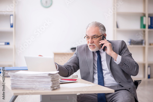 Old male employee working in the office