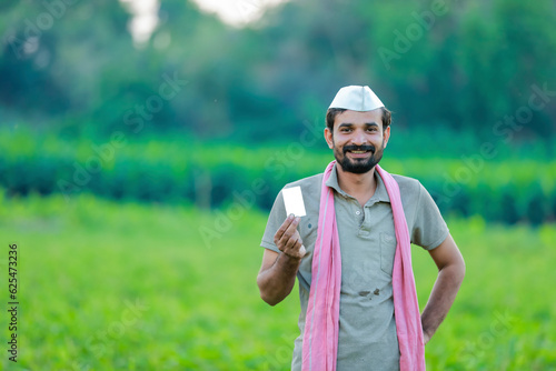 Indian farmer holding ATM card in hands, happy indian farmer, Cowpea tree