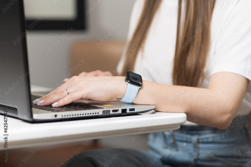 Close-up of the hands of a freelancer girl who uses a laptop in a cafe. Freelance concept. Close-up of the hands of a freelancer girl who uses a laptop in a cafe. Freelance concept.