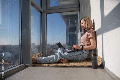 work from vacation home, remote workers. woman using a laptop, connecting to the Internet  on the balcony of your apartment. Working from Anywhere.