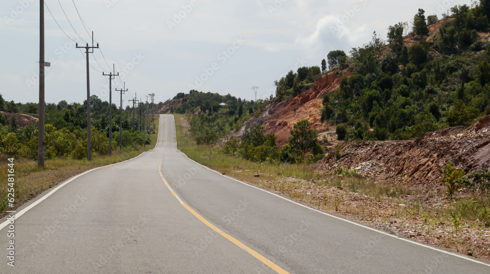 Beautiful open road or country road in Indonesia with green tree on the left and right. Pavement long road country side. Beautiful open road or country road in Indonesia with green tree on the left and right. Pavement long road country side.