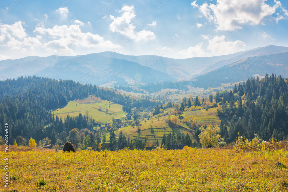 landscape with grassy meadows. distant mountain ridge beneath a sky with clouds. beautiful scenery of carpathian countryside on a sunny day in early autumn