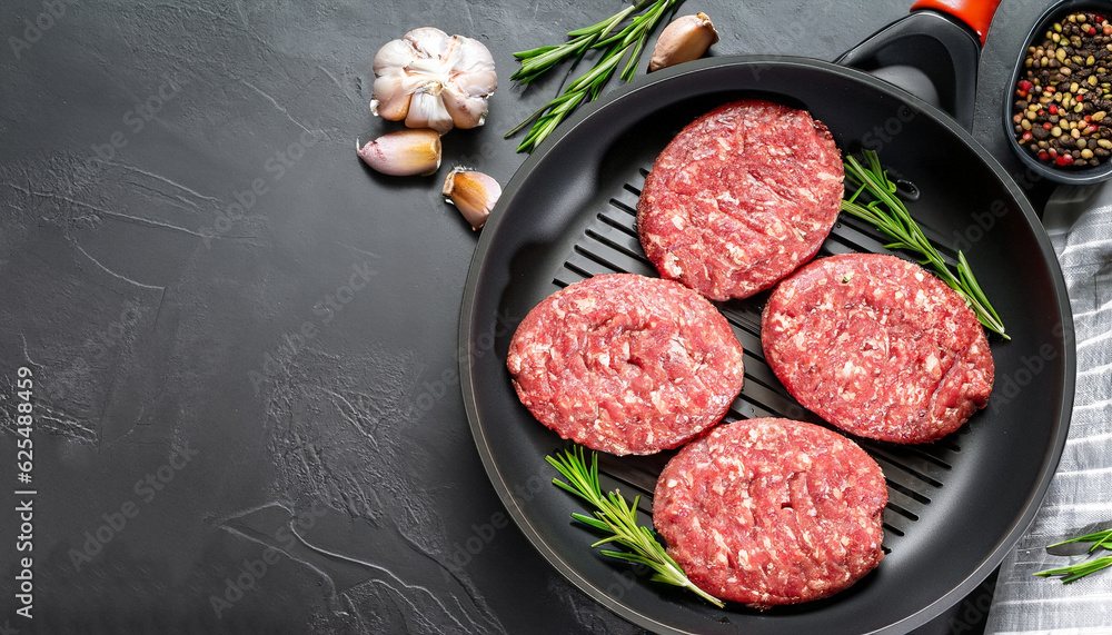 raw burgers - cutlets from organic beef meat with garlic and rosemary in a frying pan on black background, top view with copy space raw burgers - cutlets from organic beef meat with garlic and rosemary in a frying pan on black background, top view with copy space