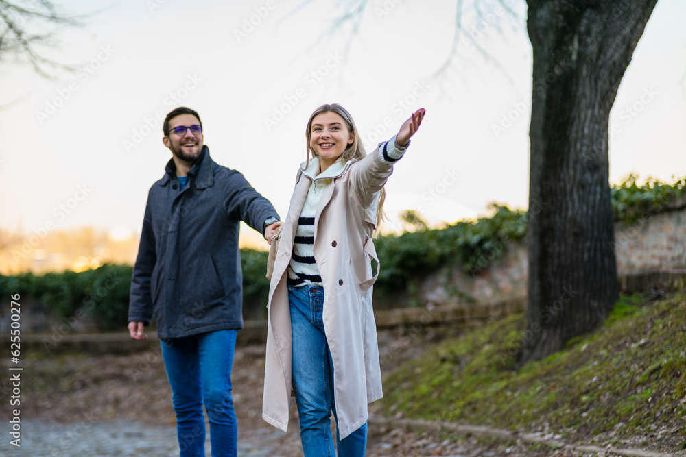 A portrait of a happy romantic couple walking outdoors in the surroundings of an old fortress A portrait of a happy romantic couple walking outdoors in the surroundings of an old fortress