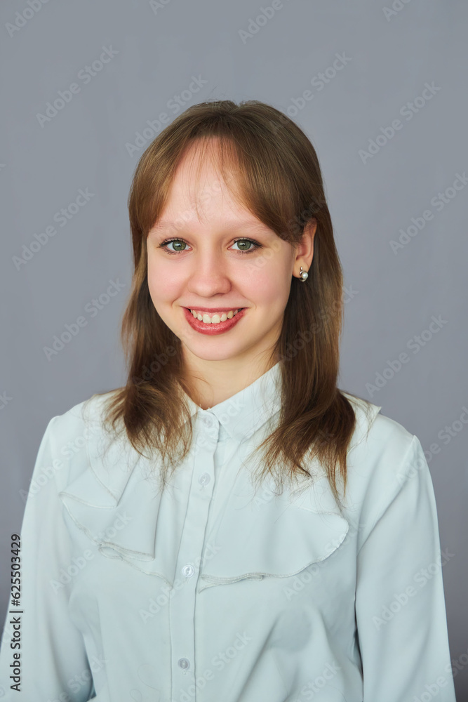 Portrait of a girl of high school age on a gray background. School uniform. Portrait of a girl of high school age on a gray background. School uniform.