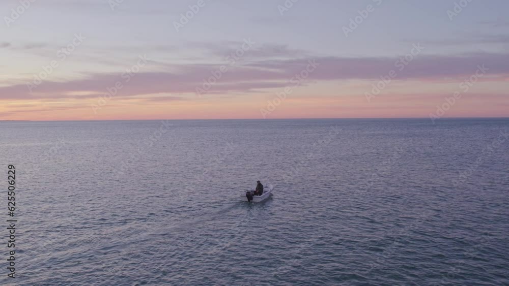 Small fishing boat on calm atlantic ocean during sunrise at Portugal, aerial Small fishing boat on calm atlantic ocean during sunrise at Portugal, aerial