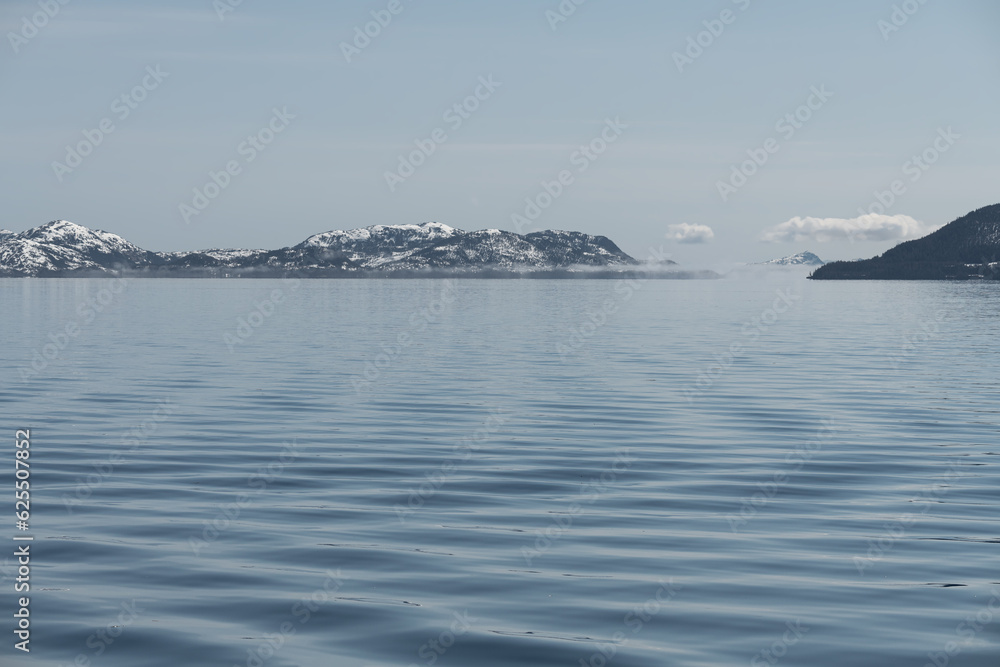 Fototapeta premium Ripples in the sea in Passage Canal inlet with sea fog in the distance, Whittier, Alaska, USA