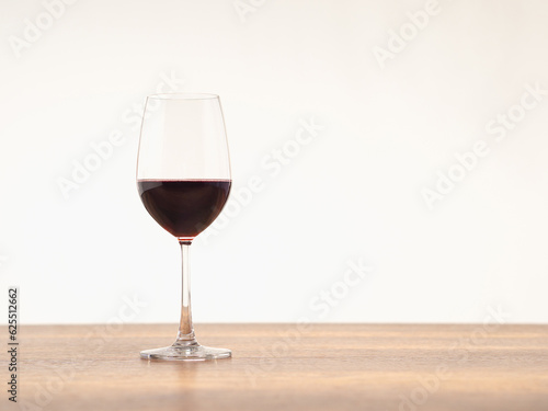 A glass of red wine on the table against a gray background.