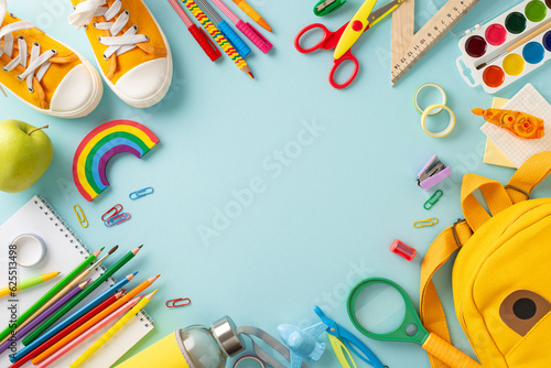 Unlock the potential of educational process with this top-view photograph showcasing variety of school supplies on an isolated blue backdrop. Utilize the copy-space for text or promotional messages