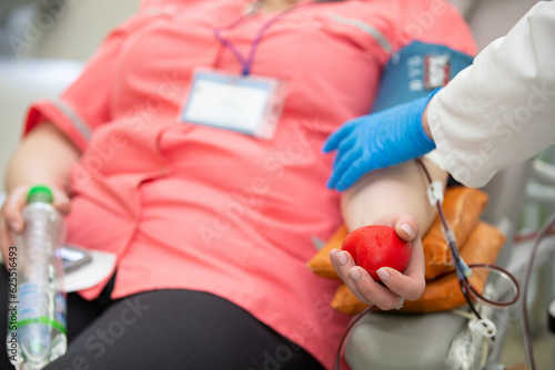 Close-up of a woman's hand squeezing a ball out of stress while donating blood at a blood donation center.