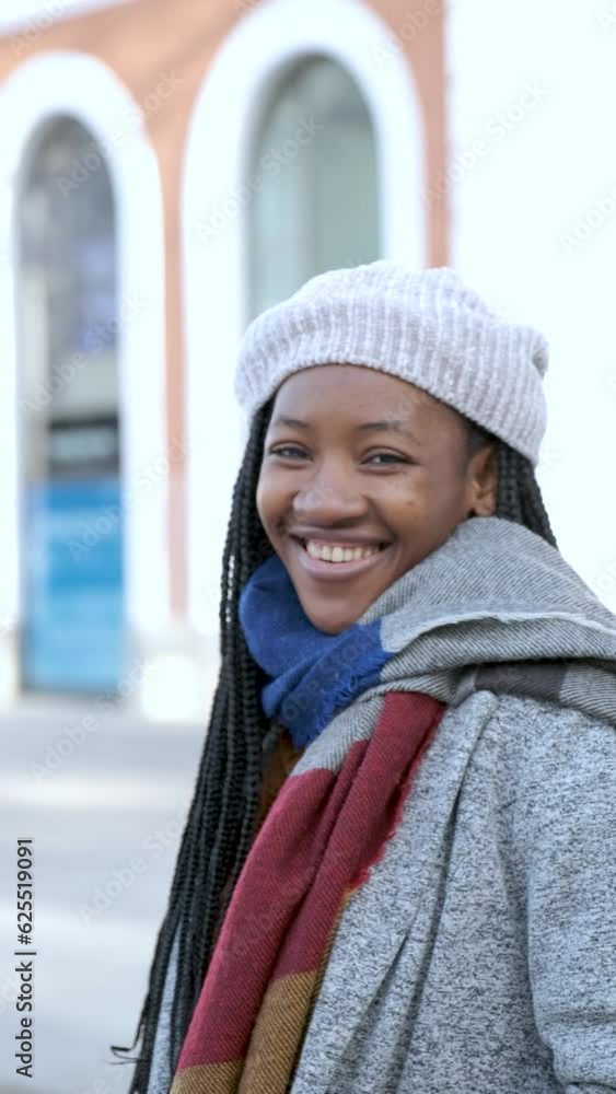 Portrait of young african woman with heterochromia looking at camera and smiling in winter. Portrait of young african woman with heterochromia looking at camera and smiling in winter.
