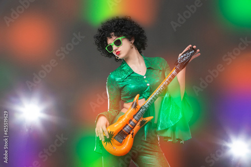 Retro disco woman with comic guitar posing against colorful stage lights.