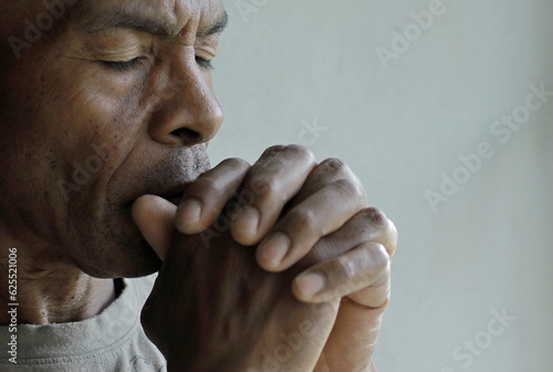 man praying to god with hands together worshiping God Caribbean man praying stock image stock photo 