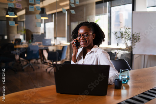 Wallpaper Mural Black businesswoman working on laptop. Portrait of beautiful businesswoman in the office. Woman taking to the phone.. Torontodigital.ca