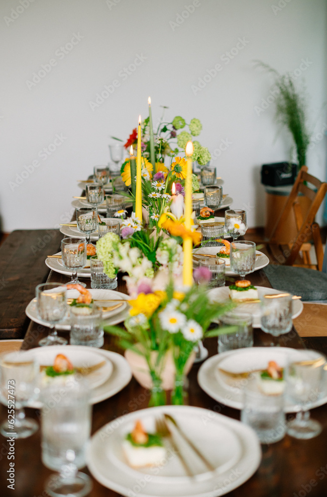 serving the table with fresh flowers and candles